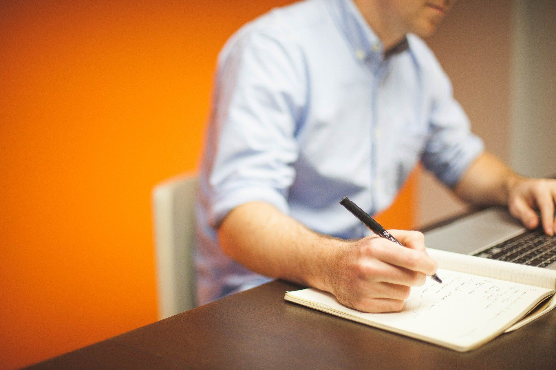 Man writing on paper on a desk; employee development