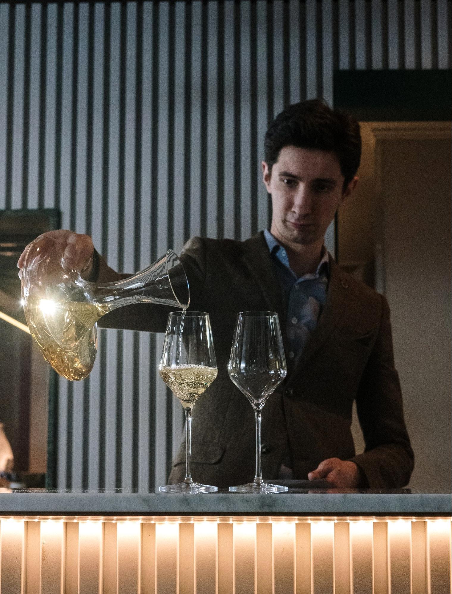 Man pouring white wine; Wine sommelier