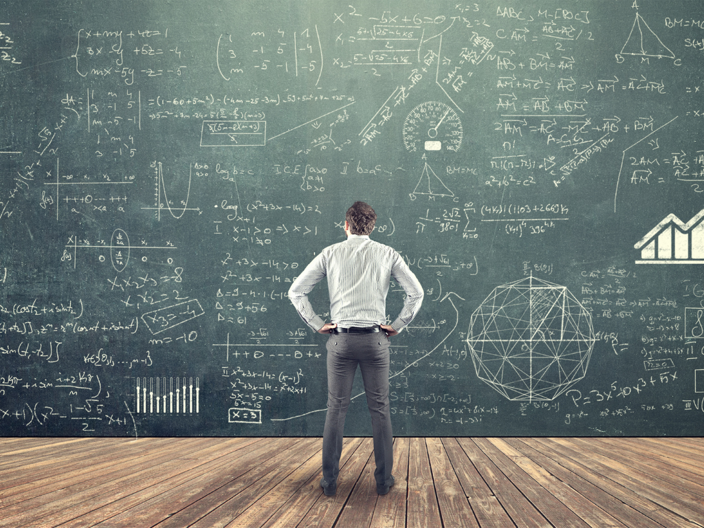 Man standing in front of equations on board; How to study for the MCAT