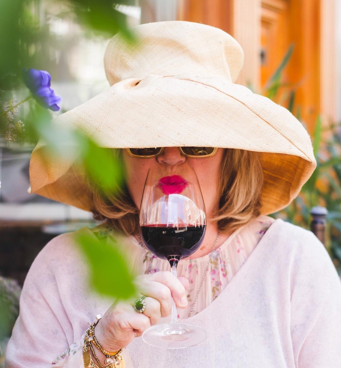 Lady in hat drinking red wine; WSET Level 3 exam